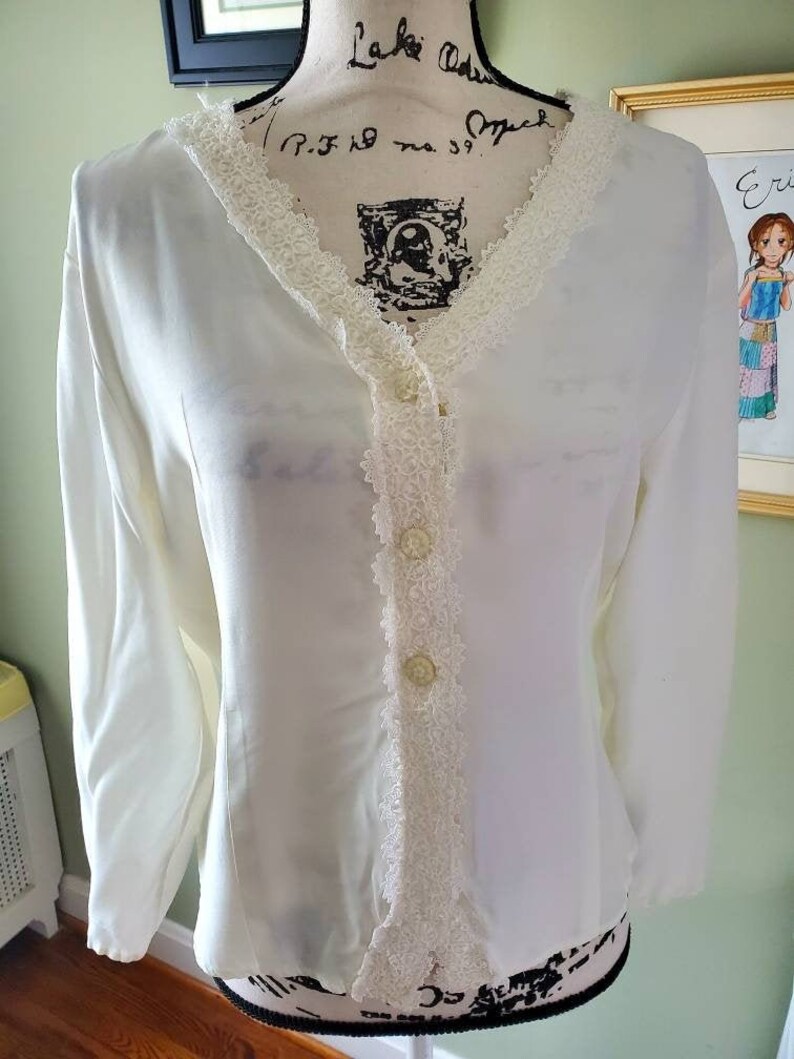 Ivory colored lace trimmed top....front buttons...long sleeves....vintage
