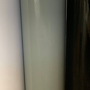 May include: Three rolls of vinyl adhesive film in white, light gray, and black.