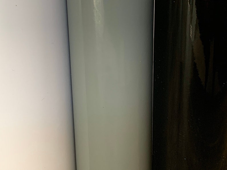 May include: Three rolls of vinyl adhesive film in white, light gray, and black.