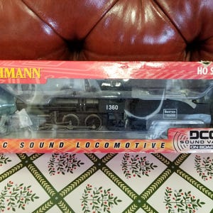 May include: A black HO scale Bachmann DCC Sound Locomotive model train in its original packaging. The box is red with white text and a clear plastic window showing the train. The train has the number 1360.