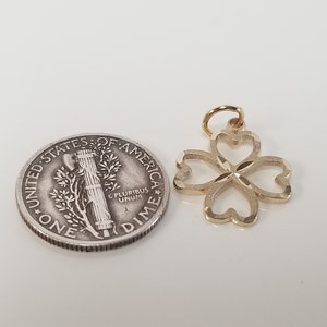 May include: A gold-colored four-leaf clover charm pendant. The charm is about the size of a US dime.