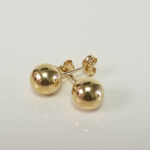 May include: A pair of gold ball stud earrings. The earrings are simple and elegant, and they would make a great gift for any occasion.