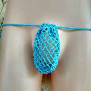 May include: A turquoise blue crocheted pouch with a net-like design. The pouch is attached to a thin string and is worn as a body accessory.