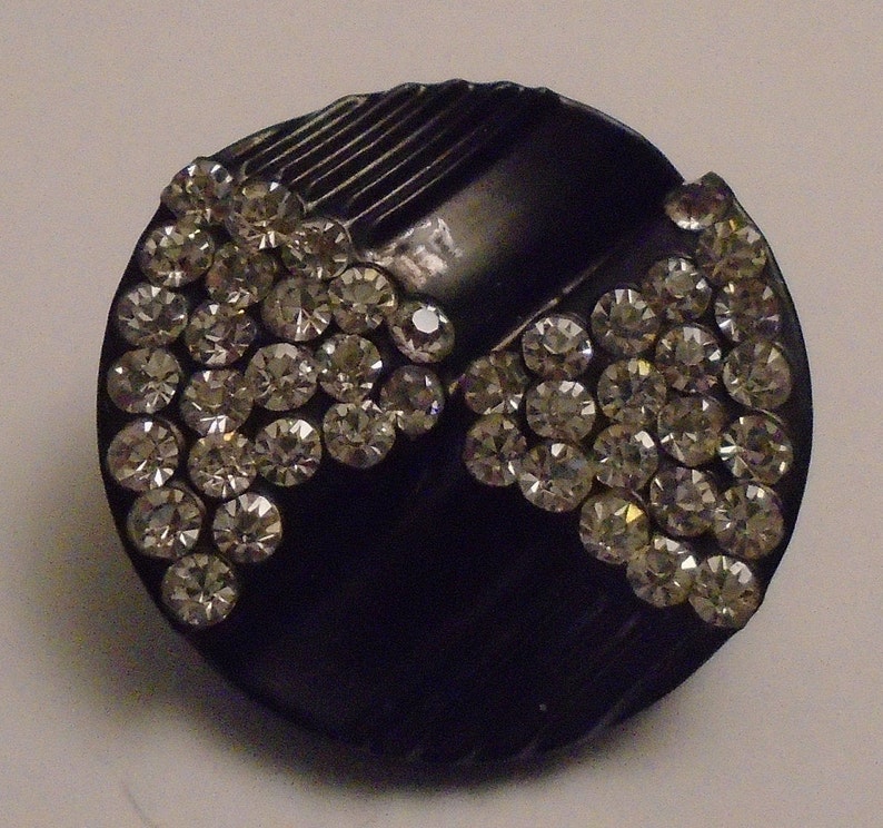 1 art deco white paste button with bow design and grooves set into black celluloid 1 116 or 27 mm dia 1900s dia ref 8984
