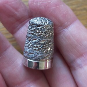 Dedal antiguo de plata con borde floral. 15/16" de alto. Talla 7 con sellos del Reino Unido. JS para James Swan. Fecha: letra D para 1928. Dedal 3.