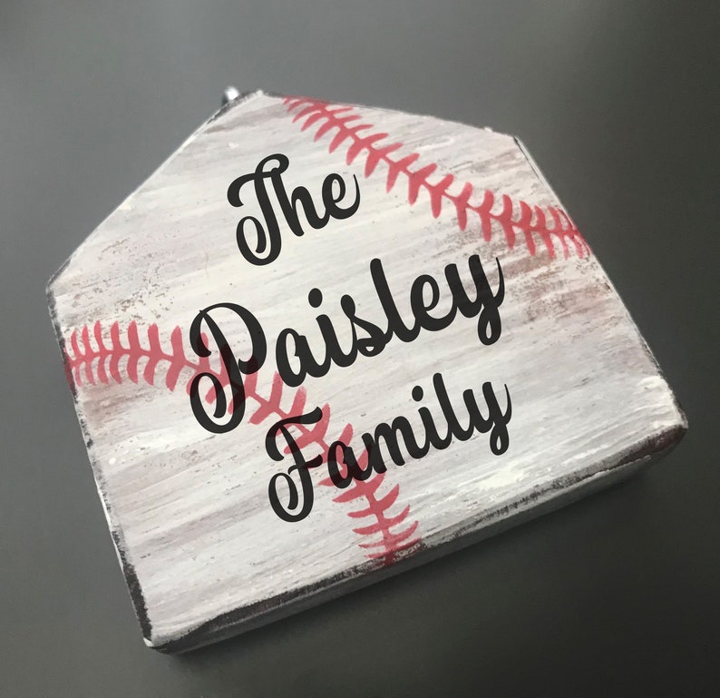 Pu&ograve; includere: Base di casa in legno bianco con cuciture rosse e il testo "The Paisley Family" in lettere nere.