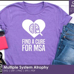 Puede incluir: Camiseta morada con un diseño de corazón blanco que presenta un cerebro y una lupa. El texto "Find a Cure for MSA" está impreso debajo del corazón. Atrofia multisistémica.