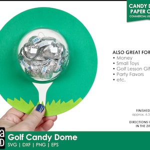 Op de afbeelding: Een groene en witte papieren golfbalkoepel met een transparante plastic bovenkant. De koepel is gevuld met kleine chocolade snoepjes. De koepel is ongeveer 16,5 cm in diameter. De tekst "CANDY DOME PAPER CRAFT" staat bovenaan de afbeelding. De tekst "ALSO GREAT FOR:" wordt gevolgd door een lijst met toepassingen voor de koepel, waaronder "Money", "Small Toys", "Golf Lesson Gift", "Party Favors" en "etc.". De tekst "FINISHED SIZE: approx. 6.5" round" staat onderaan de afbeelding. De tekst "DIRECTIONS INCLUDED IN THE ZIP FILE" staat onder de tekst van de afgewerkte maat. De tekst "TaRa REED" staat linksonder in de afbeelding. De tekst "Golf Candy Dome" staat onderin het midden van de afbeelding. De tekst "SVG | DXF | PNG | EPS" staat rechtsonder in de afbeelding.