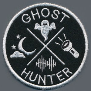 May include: White embroidered patch on a black background with the text "Ghost Hunter" and a ghost, crescent moon, and flashlight.