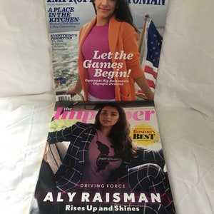 May include: Three magazine covers featuring Aly Raisman, a gymnast. The first cover is from The Improper Bostonian magazine and features Raisman in a pink shirt and orange cardigan. The second cover is from The Improper magazine and features Raisman in a plaid blazer and pink shirt with the text "Driving Force Aly Raisman Rises Up and Shines". The third cover is from The Improper magazine and features Raisman in a pink shirt with the text "Boston's Best 213 Winners".