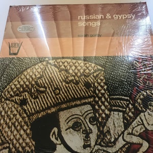 May include: A vintage vinyl record cover featuring a black and white illustration of a person wearing a hat. The text on the cover reads "russian & gypsy songs" and "sarah gorby".