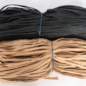 May include: Two spools of flat, woven cord. One spool is black and the other is brown.