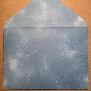 May include: A blue envelope with a white starry sky pattern.