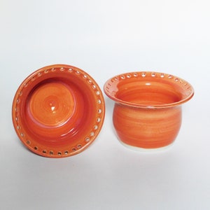 Puede incluir: Dos cuencos de cer&aacute;mica naranja con un borde blanco y un patr&oacute;n decorativo de peque&ntilde;os agujeros alrededor del borde superior.