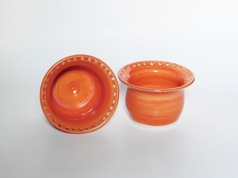 Puede incluir: Dos cuencos de cer&aacute;mica naranja con un borde blanco y un patr&oacute;n decorativo de peque&ntilde;os agujeros alrededor del borde superior.
