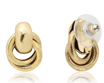 May include: A pair of gold-toned knot-style earrings. The earrings have a smooth, rounded center piece and a twisted wire design.