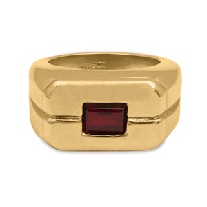 Puede incluir: Anillo de oro con una piedra preciosa roja cuadrada engastada en un marco rectangular.