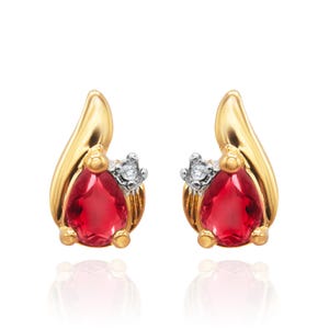 May include: A pair of gold earrings with a red gemstone and a small diamond accent.