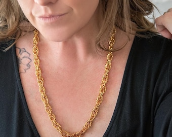 May include: A gold rope chain necklace. The chain is thick and has a chunky, textured look.