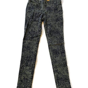May include: A pair of dark green skinny jeans with a black and white abstract print.