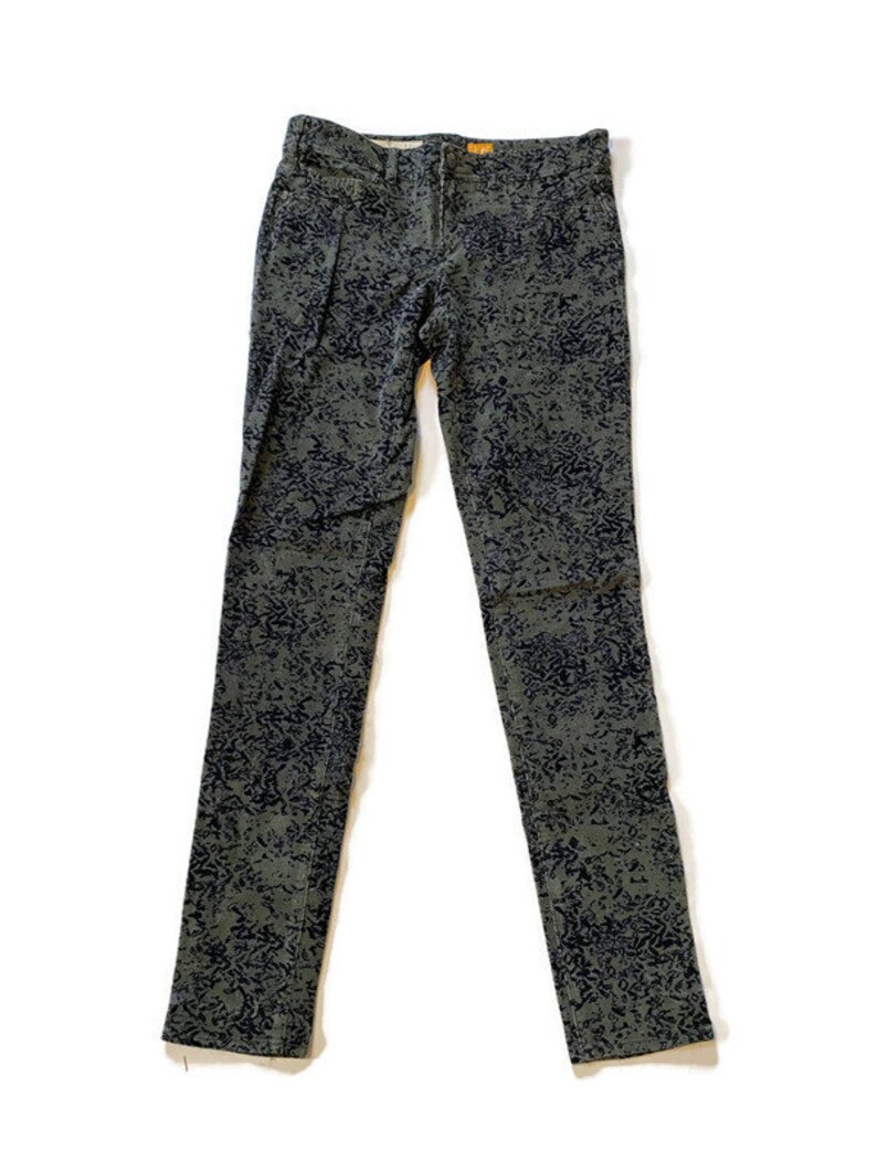 May include: A pair of dark green skinny jeans with a black and white abstract print.