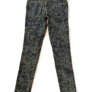 May include: A pair of dark green skinny jeans with a black and white abstract print.