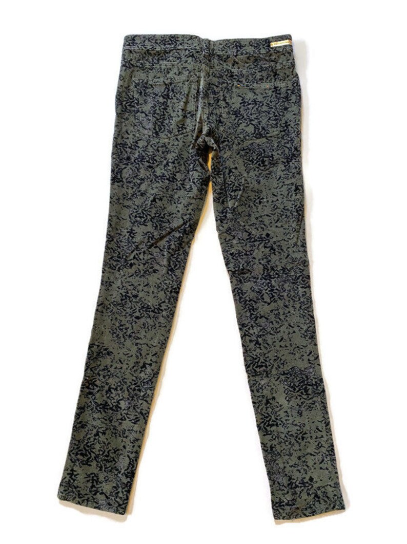May include: A pair of dark green skinny jeans with a black and white abstract print.