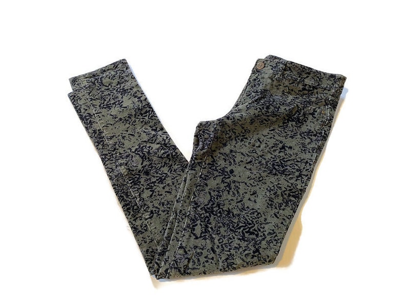 May include: Green and black patterned pants with a dark wash. The pants have a slim fit and a straight leg.