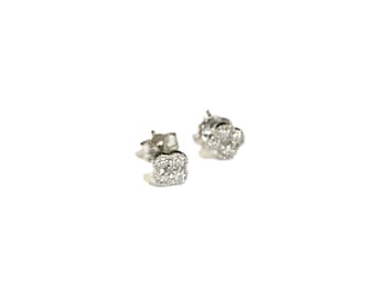 Puede incluir: Un par de pendientes de plata con un diseño cuadrado adornado con pequeñas piedras de circonita cúbica transparentes.