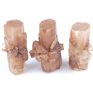 May include: Three aragonite crystal clusters. The crystals are a light brown color with a layered, textured appearance. The crystals are arranged vertically, with smaller crystal formations at the base of each.