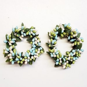 May include: A white ceramic mug with a black handle and the text "But First, Coffee" in a bold, black font. The mug is set against a blurred background, suggesting a cozy setting.