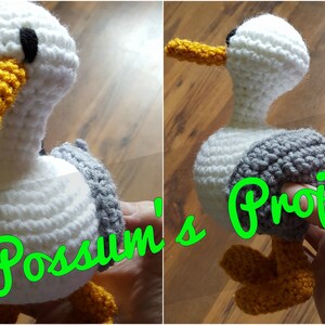 May include: A crocheted seagull toy with white, gray, and black yarn. The seagull has a yellow beak and black eyes. The toy is being held by a hand, and the text "Possum's Projects" is visible in the background.