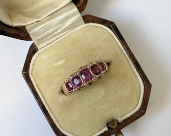 A late 19th century gold garnet five-stone ring, with split pearl double spacers