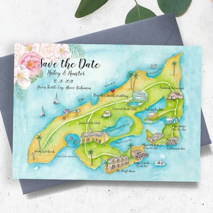 May include: A watercolour save-the-date card with a detailed island map illustration, including landmarks. The card features the text "Save the Date", names "Haley & Hunter", a date and location. The card is presented on a grey envelope.