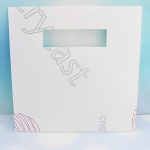 May include: White cardboard box with a gray "Cryast" logo and a rectangular window. The box has a pink and white abstract design on the bottom right corner and the word "CAS" on the bottom left corner.