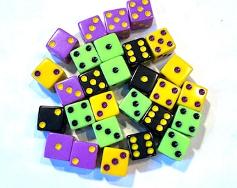 May include: A collection of dice in various colors, including purple, green, black, and yellow. The dice have black and white dots on them.