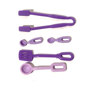 May include: A set of five purple plastic kitchen utensils, including a pair of tongs, a spatula, and three spoons.