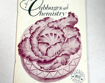 May include: A vintage book cover titled "of Cabbages and Chemistry." The cover features a watercolor illustration of a cabbage in shades of purple and pink, set on a decorative plate. The title is in a script font.