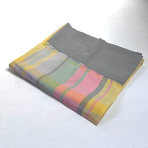 May include: A folded gray and multi-colored plaid fabric with a gray border.