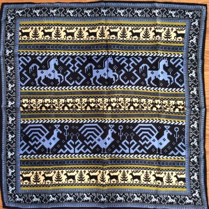 May include: A black and blue patterned fabric with a geometric design. The pattern features horses, birds, and trees. The fabric has a yellow, white, and blue color scheme.