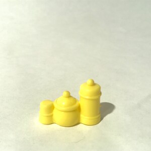 May include: A set of three yellow plastic containers with lids. The containers are different sizes and are connected together.