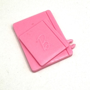 May include: Pink plastic toy notepad with the letter "B" embossed on the front.