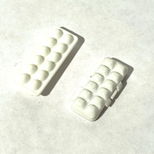 May include: Two white plastic egg cartons, one open and one closed. The cartons have 12 compartments each.