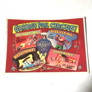 May include: A red and white poster with the text "Garbage Pail Circus!" and four different circus acts: "Revolting!" with a man holding a cannon, "Disgusting!" with a man singing, "Repugnant!" with a man being pressed by an elephant, and "Sickening!" with a man on fire.