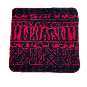 May include: A red and black patterned bath towel with a fuzzy texture.