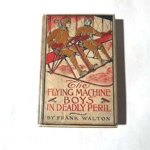 May include: Vintage book cover featuring two boys in a red and white biplane. The title reads "The Flying Machine Boys in Deadly Peril" by Frank Walton.