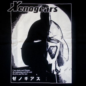 May include: Black and white graphic t-shirt featuring a robot head with a helmet and the text "Xenogears" and "ゼノギアス". The text reads "I am Alpha and Omega, the beginning and the end, the first and the last."
