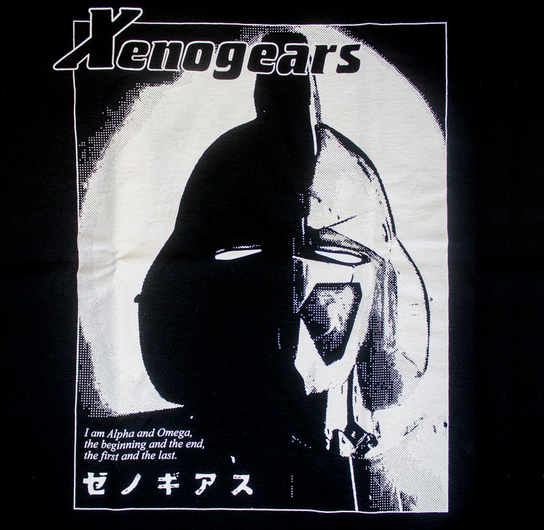 May include: Black and white graphic t-shirt featuring a robot head with a helmet and the text "Xenogears" and "ゼノギアス". The text reads "I am Alpha and Omega, the beginning and the end, the first and the last."