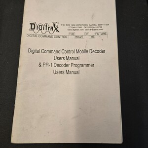 May include: A white paper with the Digitrax logo and text. The text reads "Digital Command Control Mobile Decoder Users Manual & PR-1 Decoder Programmer Users Manual". The Digitrax logo is at the top left.