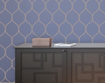 May include: A dark brown wooden cabinet with two doors and a geometric design. The cabinet is sitting on a wooden floor in front of a wall with a light blue and beige patterned wallpaper.